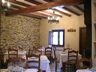 Comedor con vistas de la pared de piedra y el techo de vigas de madera.